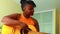 African american teenage girl practicing her skill on acoustic guitar