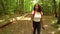 African American teenage girl young woman hiking with a red backpack and using a cell phone in forest