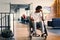 A African-American teenager in a wheelchair sits sadly amidst the bustling backdrop of a modern startup office