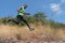 African american trail runner running on trail in natural mountain