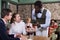 African American waiter talking with young couple