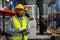 African American warehouse factory worker man hold cardboard and look at camera during working and stay in front other coworker