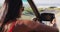 African american woman adjusting side rear view mirror while sitting in convertible car