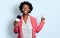 African american woman with afro hair holding reporter microphone surprised with an idea or question pointing finger with happy