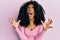 African american woman with afro hair wearing casual pink shirt crazy and mad shouting and yelling with aggressive expression and