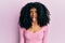 African american woman with afro hair wearing casual pink shirt sticking tongue out happy with funny expression