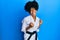 African american woman with afro hair wearing karate kimono and black belt very happy and excited doing winner gesture with arms