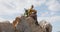 African american woman with backpack enjoying the view sitting on the rocks while hiking