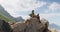 African american woman with backpack enjoying the view sitting on the rocks while hiking