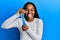 African american woman with braided hair holding slime sticking tongue out happy with funny expression