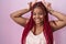 African american woman with braided hair standing over pink background posing funny and crazy with fingers on head as bunny ears,