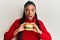 African american woman with braids eating hamburger afraid and shocked with surprise and amazed expression, fear and excited face