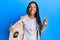 African american woman with braids showing detective badge smiling with an idea or question pointing finger with happy face,