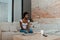 African american woman with closed eyes on sofa near coffee table with gadgets, plate with toast, cup of tea and remote