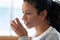 African American woman drinking still water at home