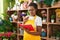 African american woman florist reading notebook with doubt expression at flower shop