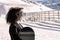 African American woman with goggles and a snowboard on a snowy mountain during winter