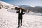 African American woman with goggles and a snowboard on a snowy mountain during winter