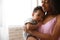 African-American woman  her baby at home. Happiness of motherhood