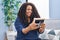 African american woman looking picture sitting on sofa at home