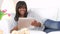 African American woman lounging on couch with tablet