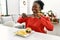 African american woman make photo by smartphone to hamburger sitting on table by christmas tree at home