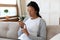 African American woman measure blood sugar level at home