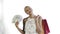 African american woman with money card and shopping bags. white background. White dress with flowers