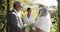 African american woman officiating wedding ceremony of senior biracial couple in garden, slow motion