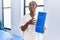 African american woman physiotherapist smiling confident holding foam roller at rehab clinic