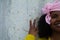 African-american woman with a pink scarf against the fight against breast cancer with a yellow t-shirt making a gesture with her