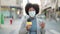 African american woman reporter wearing medical mask working using microphone at street