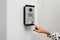 African-American woman ringing intercom with camera in entryway, closeup