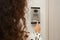 African-American woman ringing intercom with camera in entryway, closeup