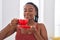 African american woman smiling confident drinking coffee at home