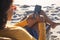 African american woman in sunglasses sitting in deckchair using smartphone on sunny beach