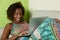 African american woman surfing the net with notebook on couch