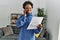 African american woman talking on smartphone reading invoice at home