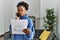 African american woman talking on smartphone reading invoice at home