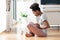 African American woman using a laptop in her living room - Black