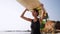 African american woman walking with surfboard on her head on ocean beach. Black female surfer posing with surf board