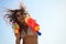 African American woman with water guns against blue sky, low angle view. Space for text