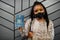 African american woman wearing black face mask show Suriname passport in hand. Coronavirus in America country, border closure and