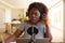 African american woman wearing headphones and using microphone, talking, making notes during podcast