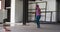 African american woman wearing hoodie skipping with rope in an empty urban building