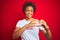 African american woman wearing sarcastic comments t-shirt over red isolated background smiling in love showing heart symbol and