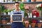 African american woman working at florist holding open sign clueless and confused expression