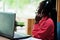 African american woman works in a call center operator and customer service agent wearing microphone headsets working on laptop