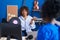 African american women musicians holding vinyl disc speaking at music studio