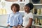 African american women shop assistants standing with serious expression at clothing store